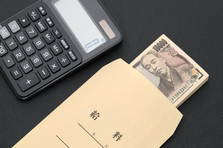 Japanese salary envelope and calculator, Translation: Salary, The banknotes are written as "10,000 yen" in Japanese.の写真素材