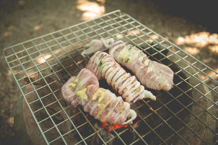 Grilled squids with butter and herb on flaming grill (vintage color)の写真素材