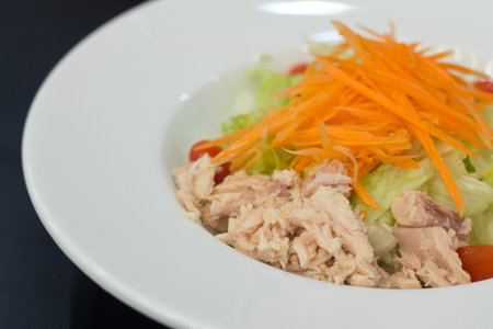Healthy tuna salad with fresh ingredients in white dishの写真素材