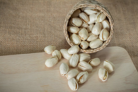 Salty pistachios nuts on rustic wooden blockの写真素材