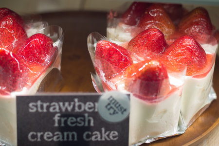 Slice of sweet strawberry cake for sell soft focusの写真素材