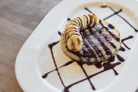 Pancakes With Chocolate Syrup and banana sliced soft focusの写真素材