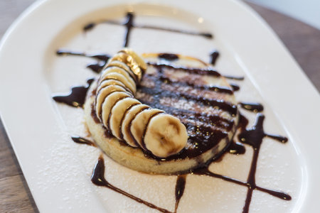 Pancakes With Chocolate Syrup and banana sliced soft focusの写真素材
