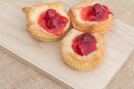 Fresh fruit pie tart with cherry that serve on wood block capture with natural lightの写真素材