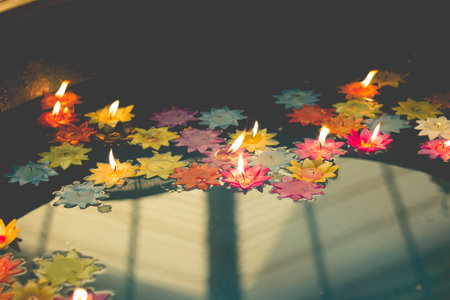 Photo of flower-shaped candle burning in the pool of spirit at chinese temple.vintage color toneの写真素材