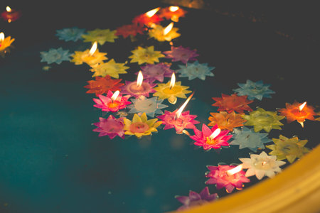 Photo of flower-shaped candle burning in the pool of spirit at chinese temple.vintage color toneの写真素材