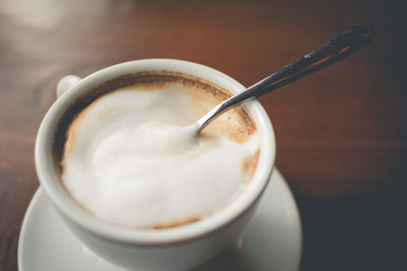Hot cappuccino coffee on wood table  Filtered image processed vintage effect.の写真素材