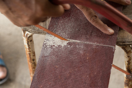 The carpenter is sawing the brown planksoft focus