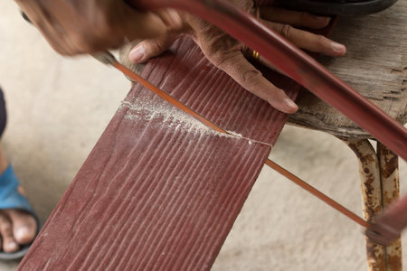 The carpenter is sawing the brown planksoft focusの写真素材