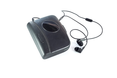 Old fashioned music of cassette player and black earphones isolated on white backgroundの写真素材