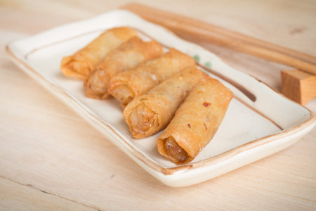 Deep fried spring rolls with pork stuffed serve on wood table that found in East Asian and Southeast...