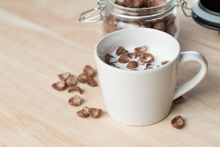 milk and chocolate cereal cornflakes in white cup that ready for serving in breakfast time