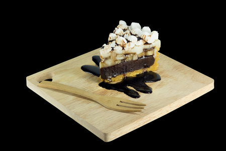 chocolate cake with biscuit and banana stuffed isolated on black background