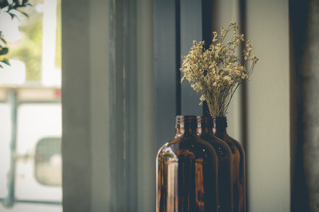 dried flowers in the brown glass use for decoration on the dining table (soft focus)の写真素材