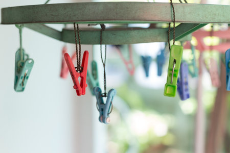Clothes pegs or clothespins hang on a cord. Plastic clothes pegs on a washing line.(selective focus)の写真素材