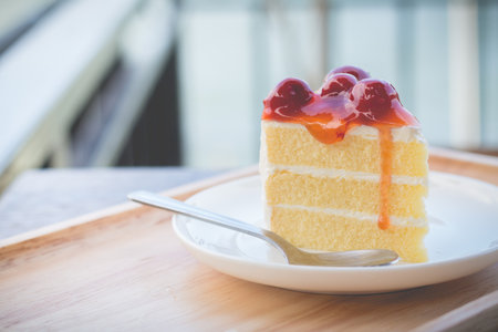 Sponge cake with cherry syrup. Peace of cherry cake served in afternoon time. Cherry cake in cozy outdoor cafe.の写真素材