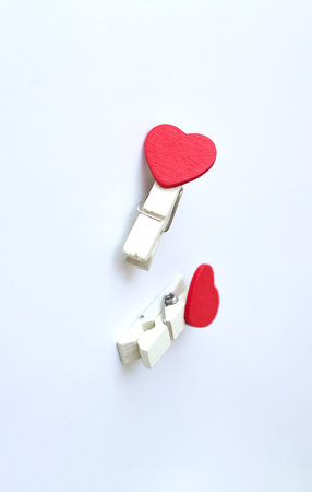 wooden clothes pin or cloth pegs with heart shape design on a white background