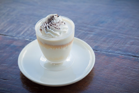 Delicious milk pudding with grated chocolate over napkin on wood tableの写真素材