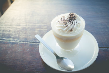 Delicious milk pudding with grated chocolate over napkin on wood tableの写真素材
