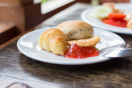 Fresh Croissants with strawberry jam on rustic wooden background. Selective focusの写真素材
