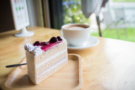 blueberry cake and hot coffee mocha with foam milk in countryside cafeの写真素材