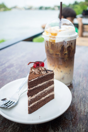 chocolate cake with cherry topping and ice coffee mocha in outdoor cafeの写真素材
