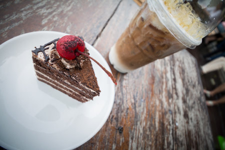 chocolate cake with cherry topping and ice coffee mocha in outdoor cafeの写真素材