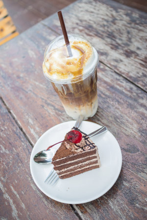 chocolate cake with cherry topping and ice coffee mocha in outdoor cafeの写真素材