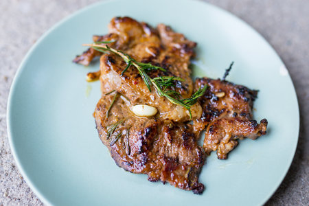 The picture of Round plate with grilled beef steak and rosemaryの写真素材