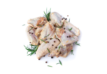 Raw chicken wings with garlic, pepperand rosemary isolated on white backgroundの写真素材
