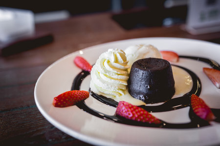 The picture of hot chocolate lava cake with vanilla ice cream and fresh strawberryの写真素材