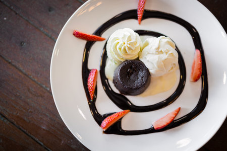 The picture of hot chocolate lava cake with vanilla ice cream and fresh strawberryの写真素材