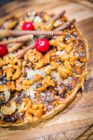 Picture of cashew nut and caramel syrup on chocolate tart cakeの写真素材