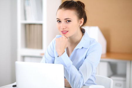 Young business woman working on laptop in office. Successful business concept.の写真素材
