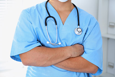 Portrait of unknown male surgeon doctor holding his stethoscope, crossed armsの写真素材