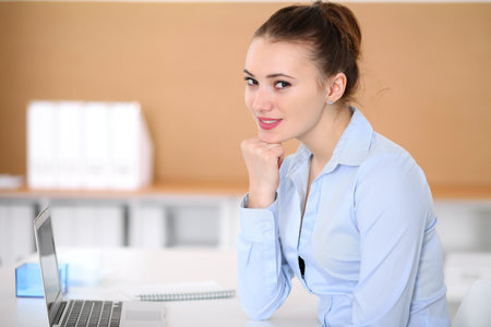Young business woman working on laptop in office. Successful business concept.の写真素材