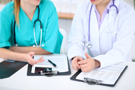 Female doctor  and young surgeon intern in hospitalの写真素材