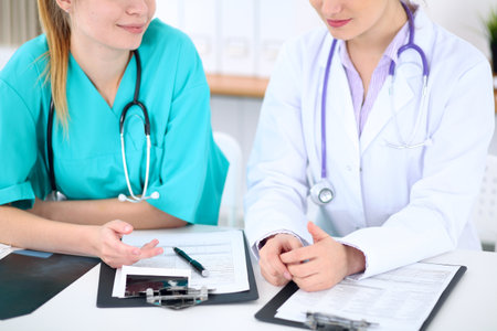 Female doctor  and young surgeon intern in hospitalの写真素材