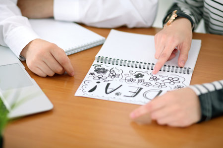 Young business woman designer discussing architecture project with client in office. Successful...