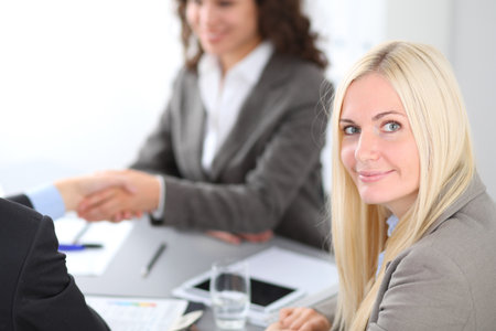 A group of business people at a meeting on the background of office. Focus on a beautiful blondeの写真素材