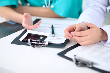 Female doctor  and young surgeon intern in hospitalの写真素材