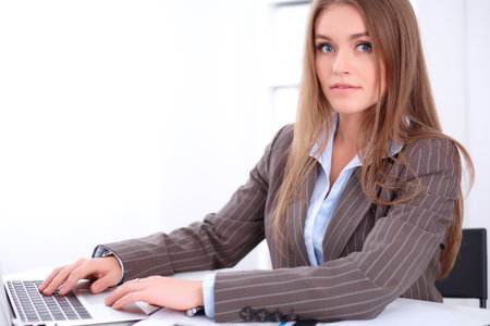 young business woman sitting at the desk on office backgroundの写真素材