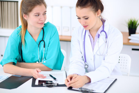 Female doctor  and young surgeon intern in hospitalの写真素材