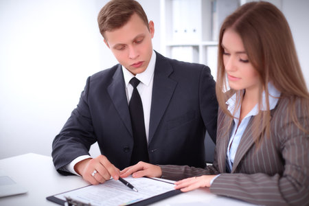Image of businessman and business woman using clipboard  at meetingの写真素材