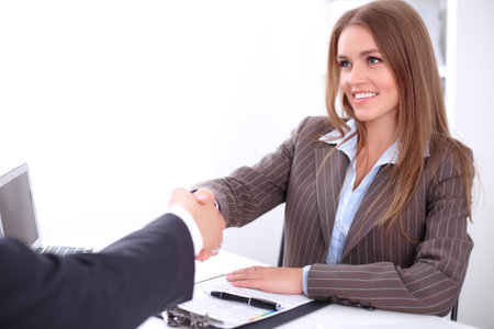 young business woman handshaking  sitting at the desk on office background, copy space area at the left upper cornerの写真素材