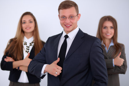 Cheerful business man  with colleagues in the background, thumbs upの写真素材
