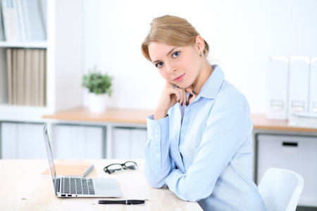 Young blonde business woman with laptop in the office. Business conceptの写真素材