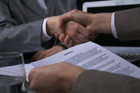 Business people shaking hands after contract signing at meeting. Low key lightingの写真素材