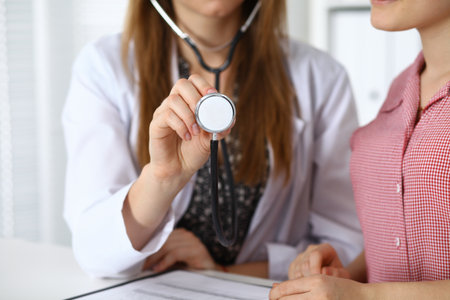 Doctor with a stethoscope in the hand. Physician  is ready to examine her female patient.の写真素材