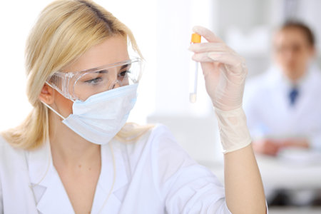 Female scientific research team with clear solution in laboratoryの写真素材